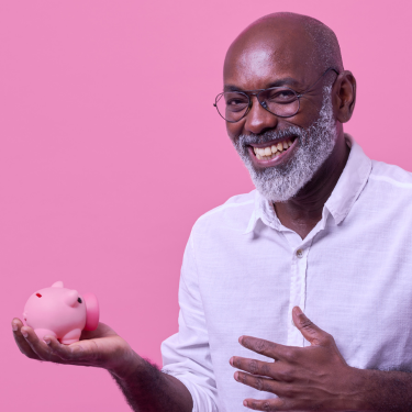 smiling man holding piggy bank